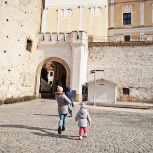 Famille avec enfants marchant sur l esplanade pavee d un chateau europeen ancien
