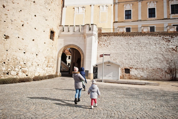 Famille avec enfants marchant sur l esplanade pavee d un chateau europeen ancien